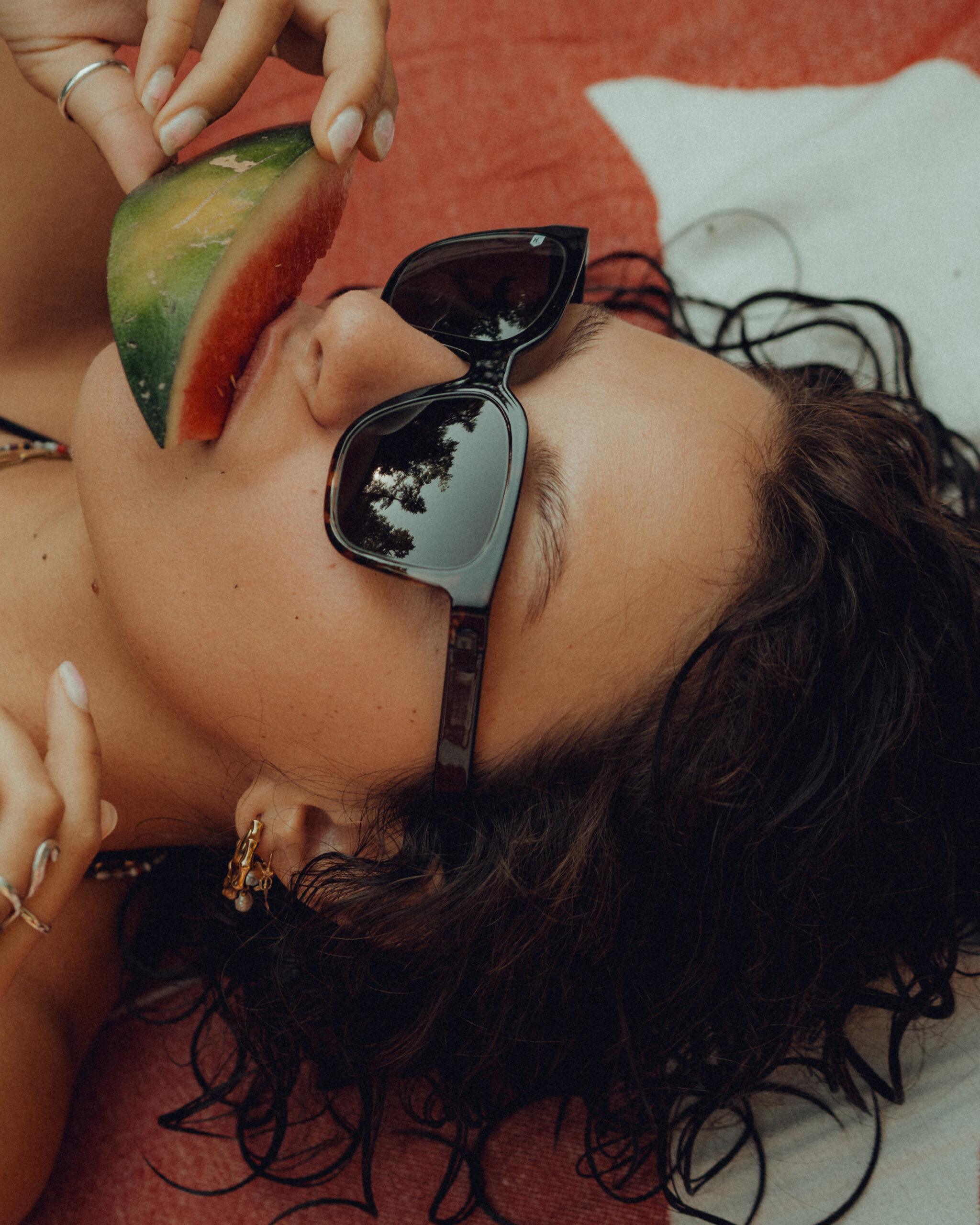 Nahaufnahme einer gloryfy Sonnenbrille im Sommer-Setting am Strand